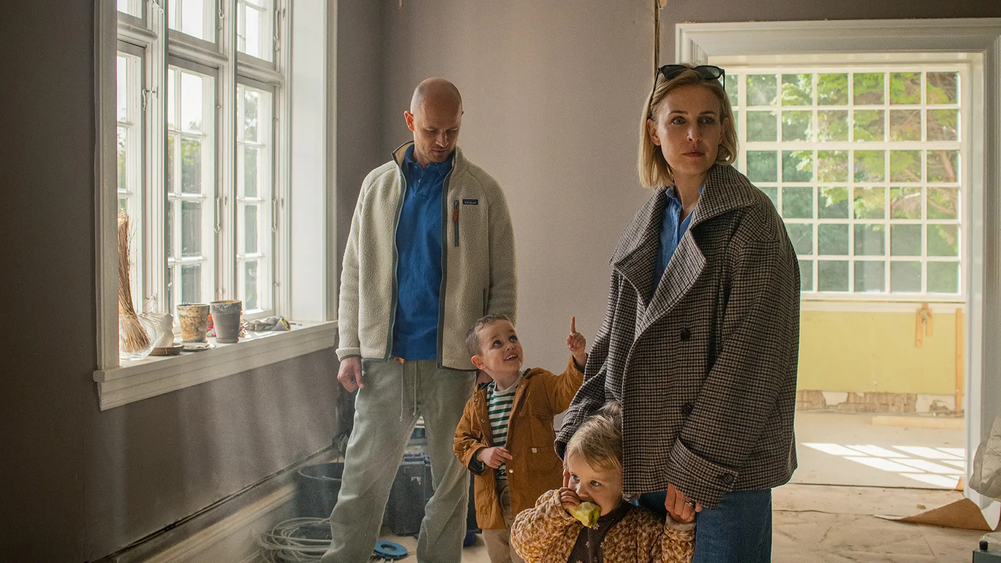 Familie kigger på hus, de overvejer at købe. De går rundt i stuen.