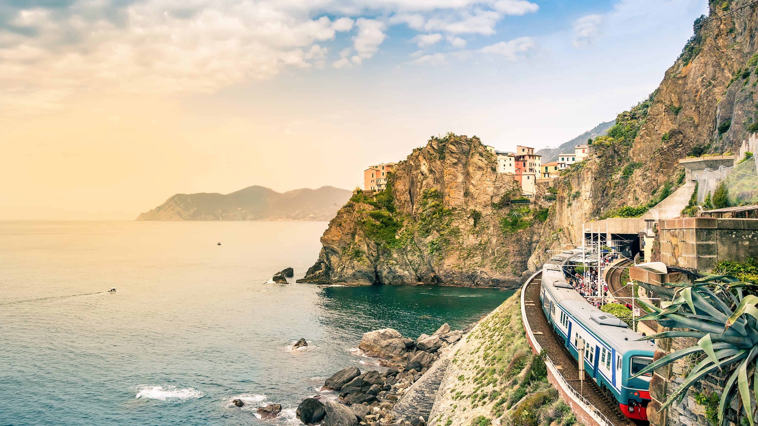 Tog kører langs kysten i Cinque Terre, Italien