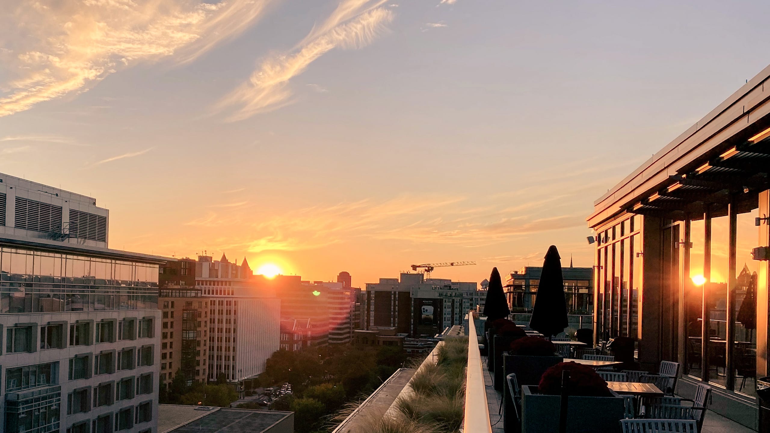 Solnedgang bag ved erhvervsbygninger og terrasse i solen