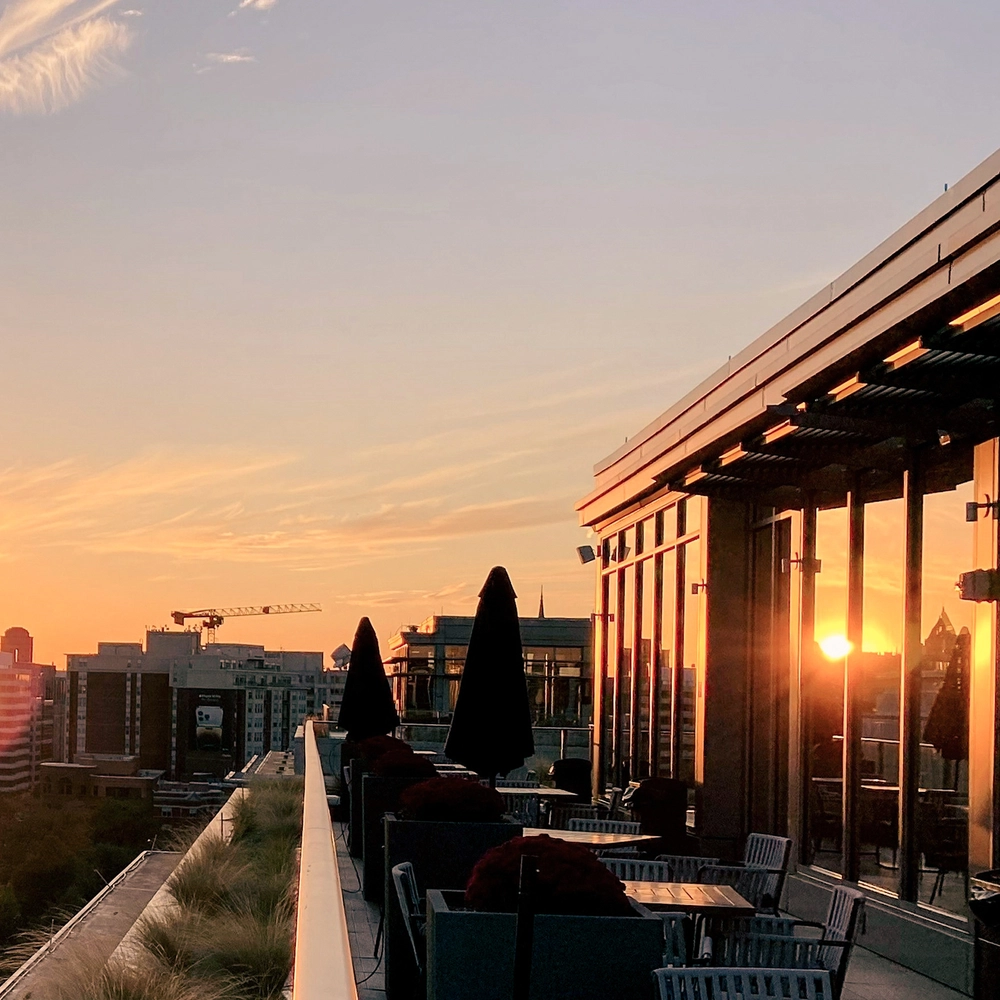 Solnedgang bag ved erhvervsbygninger og terrasse i solen