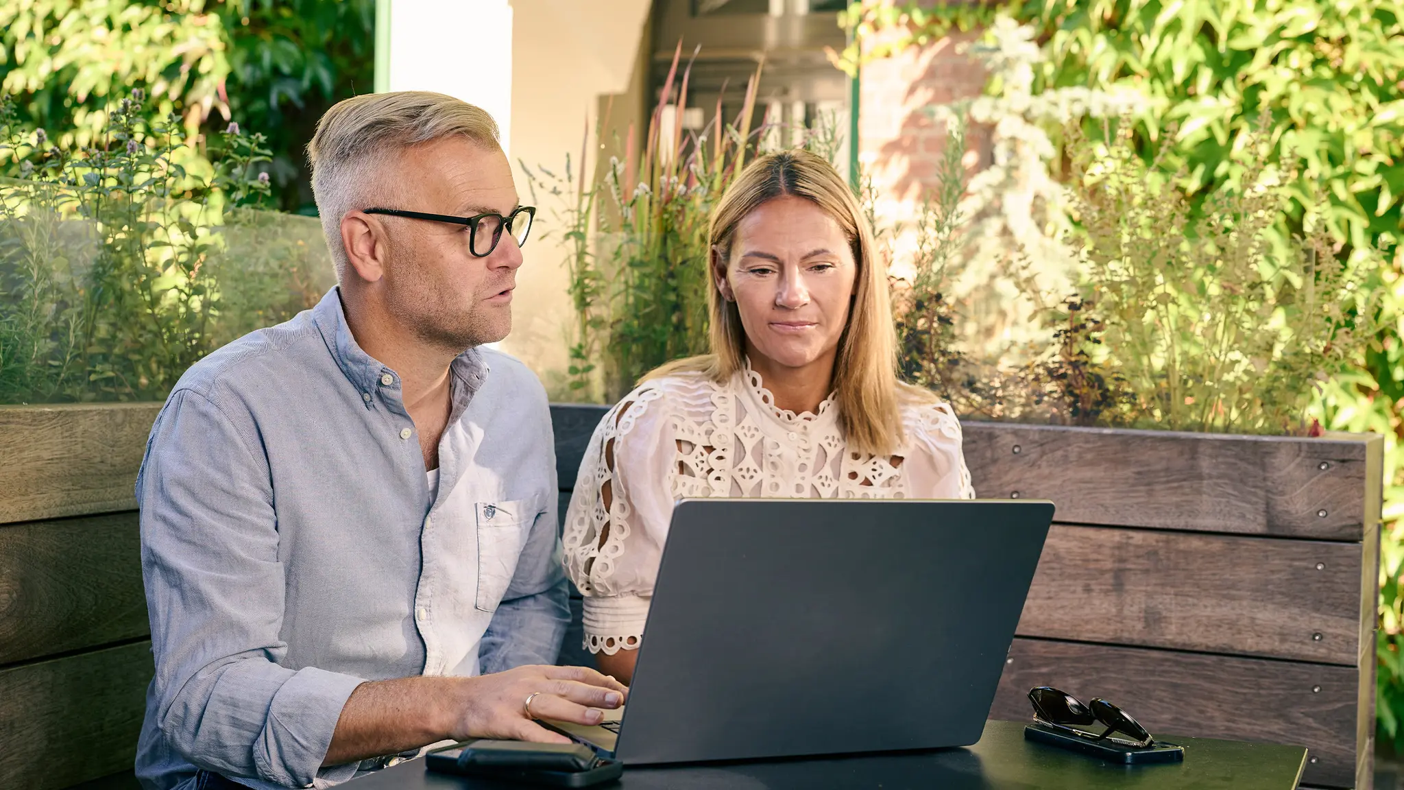 Mand og kvinde arbejder ved en pc i udemiljø