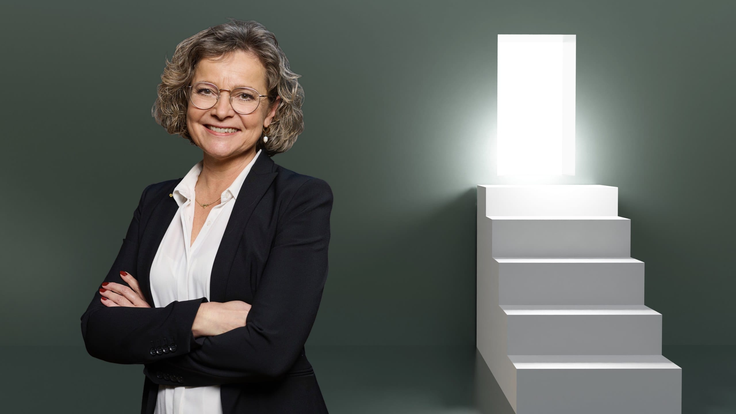 Formueøkonom Bettina Brask, til højre en trappe med en kraftig lampe øverst