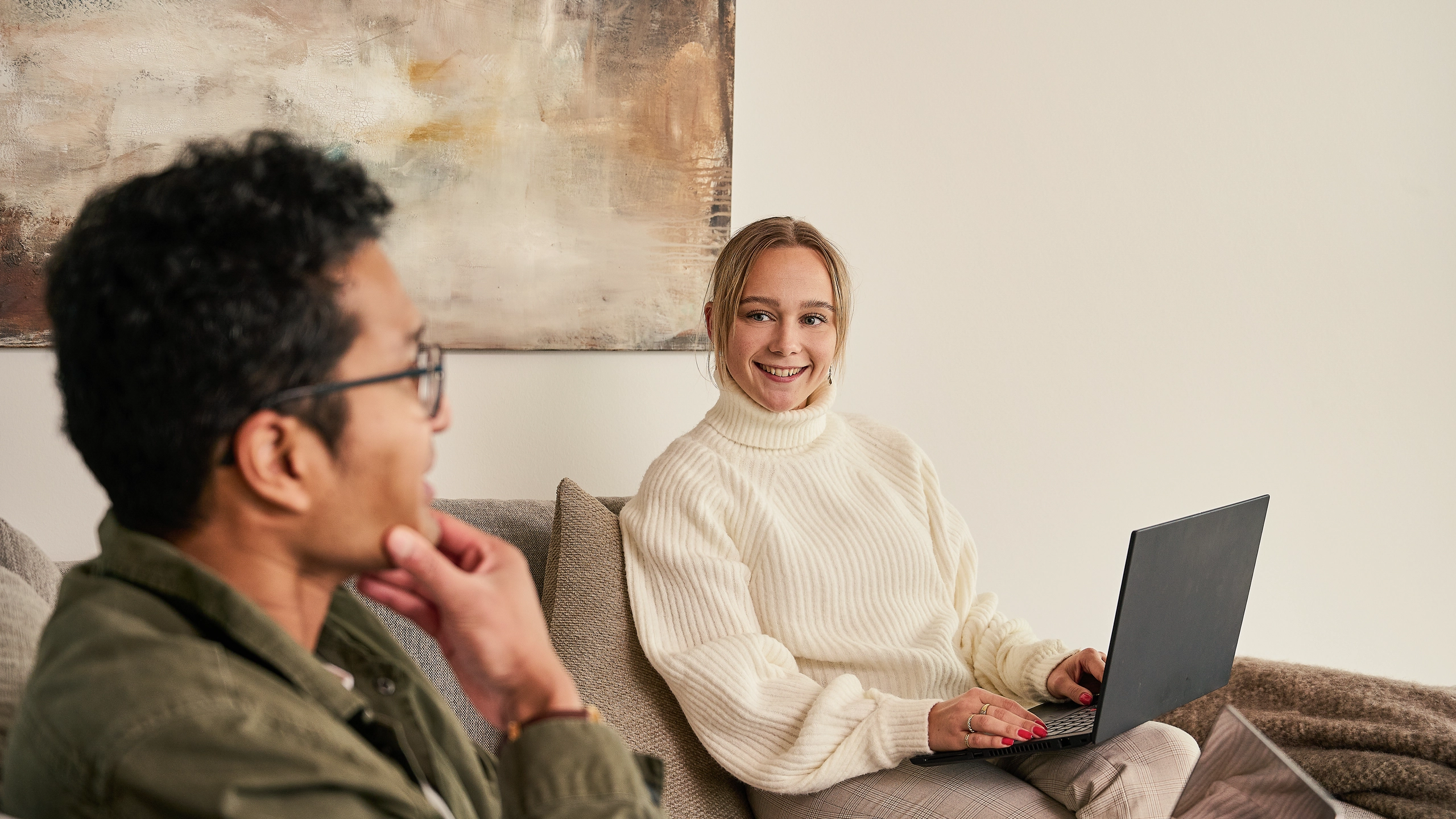 Mand og kvinde med laptop i sofa
