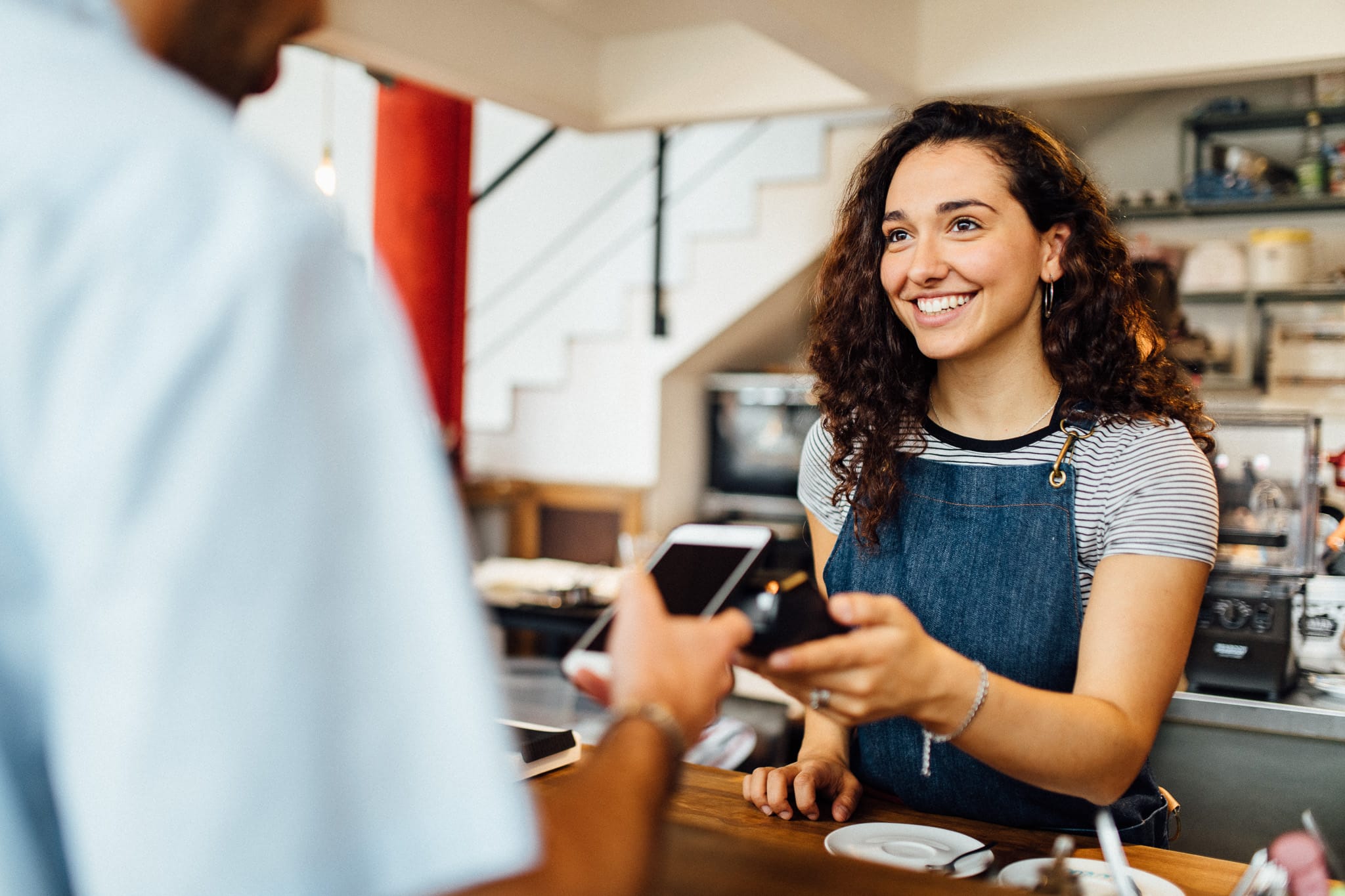 Mobilbetaling ved kvinde i cafe