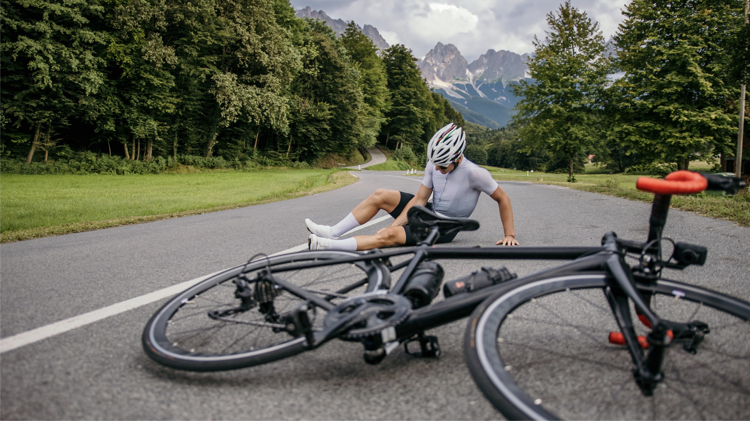 Styrtet cykelrytter på bjergvej