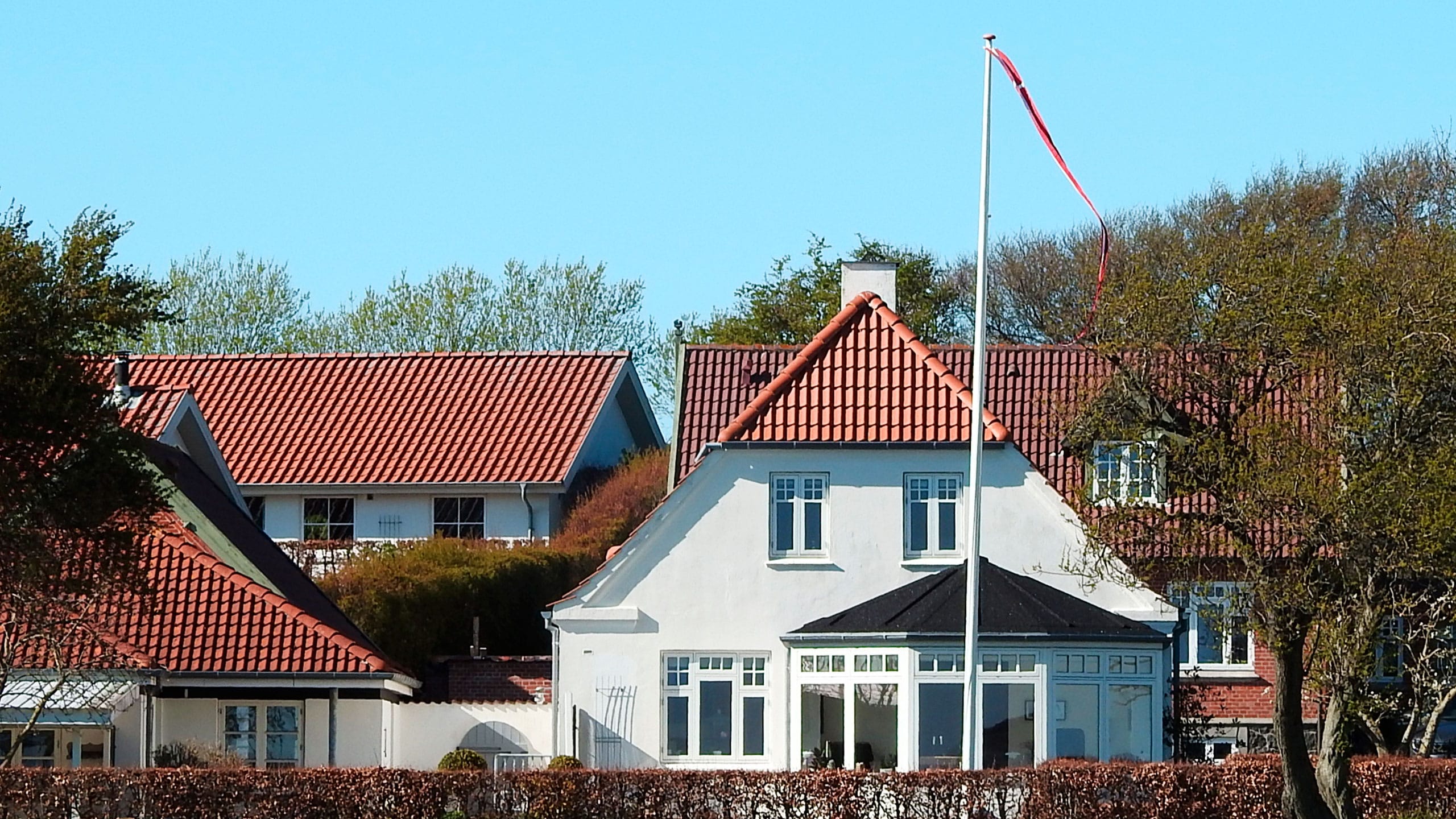 Hvidt parcelhus med flagstang
