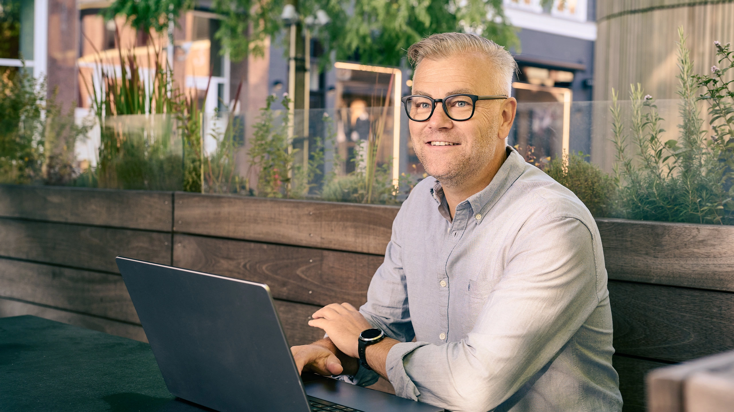Mand der sidder udenfor med sin bærebare computer