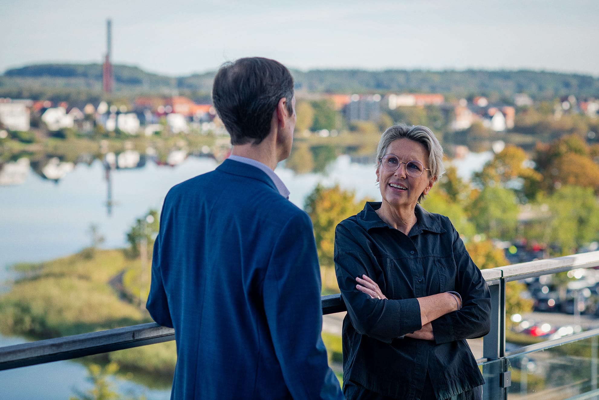 Mand og kvinde taler på tagterrasse med udsigt