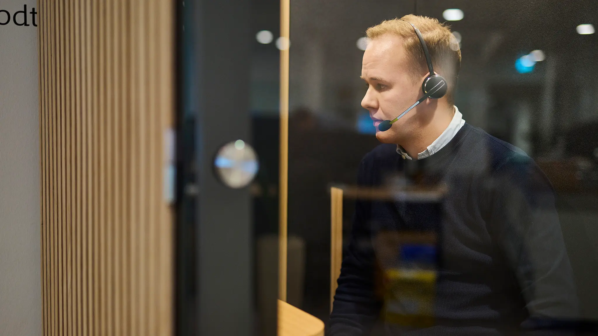 Mand snakker i telefon via headset