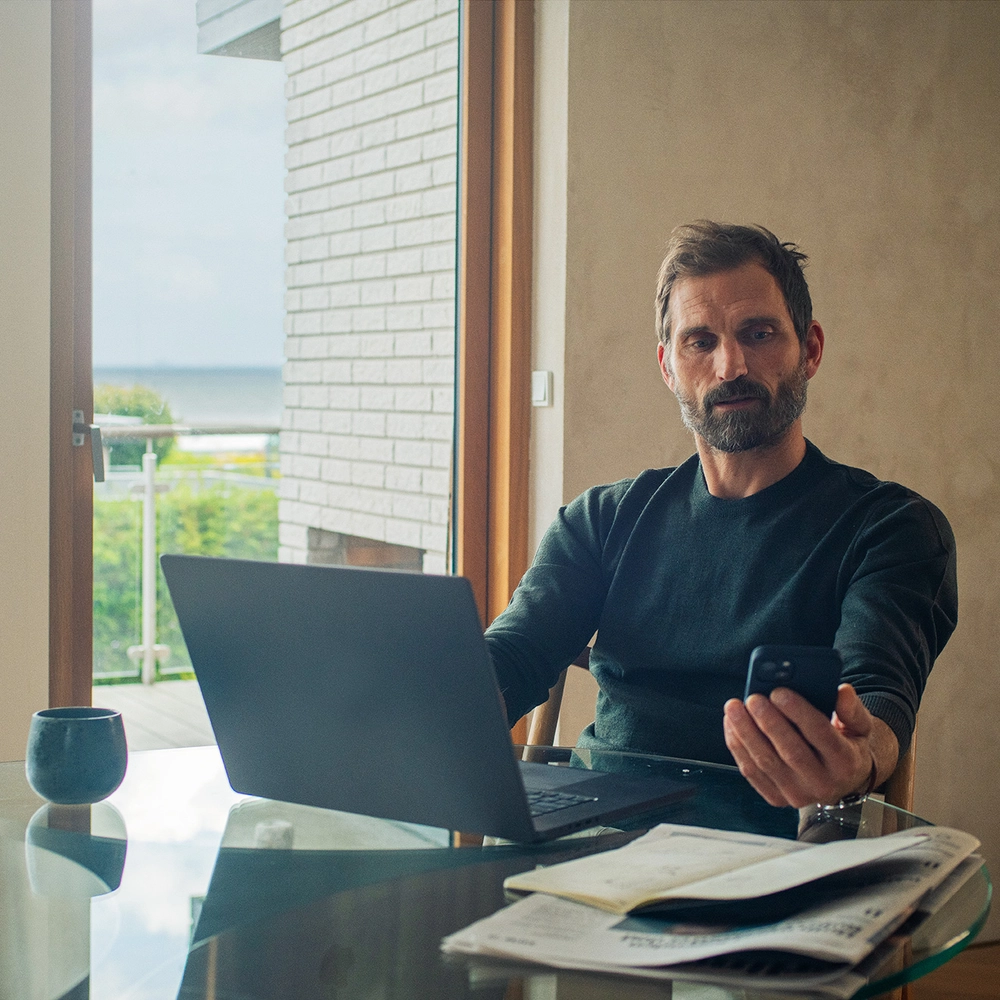 Mand arbejder med mobil og computer