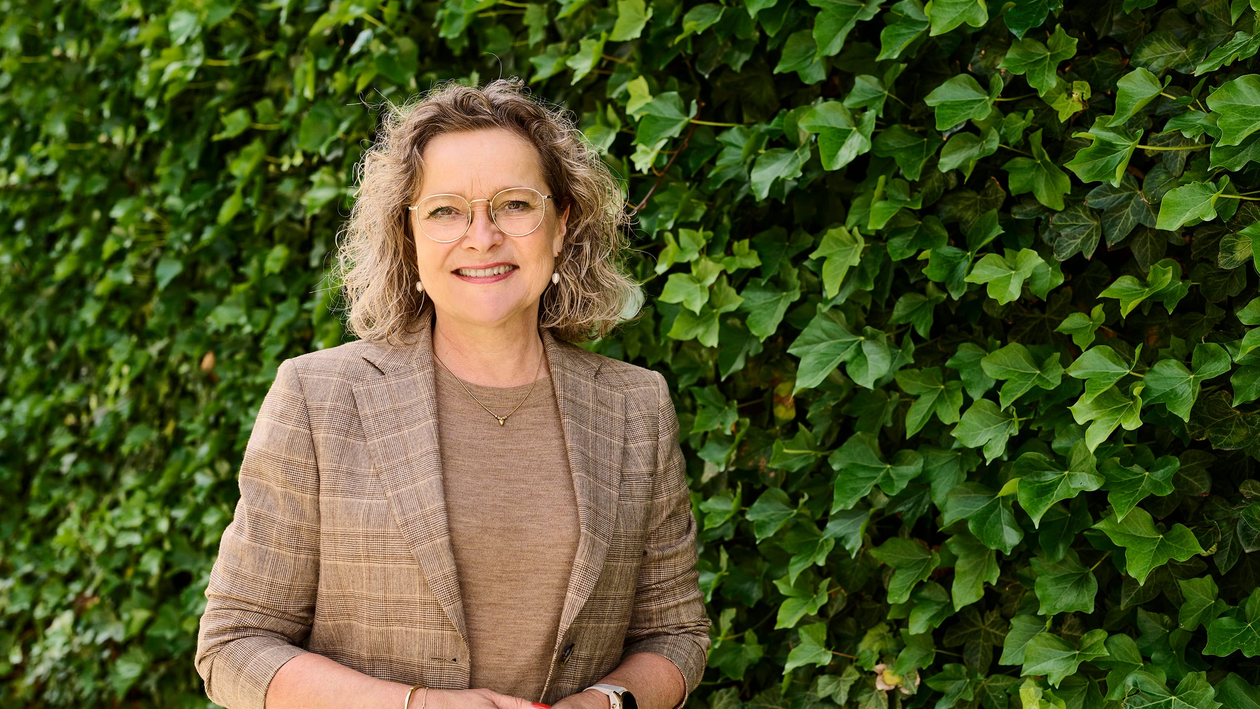 Formueøkonom Bettina Brask foran grøn beplantning