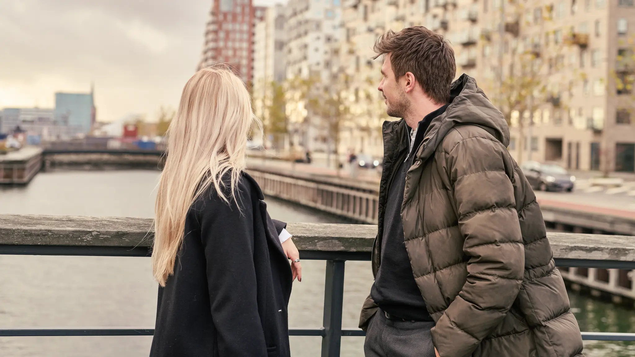 Kvinde og mand kigger ud over vandet fra bro