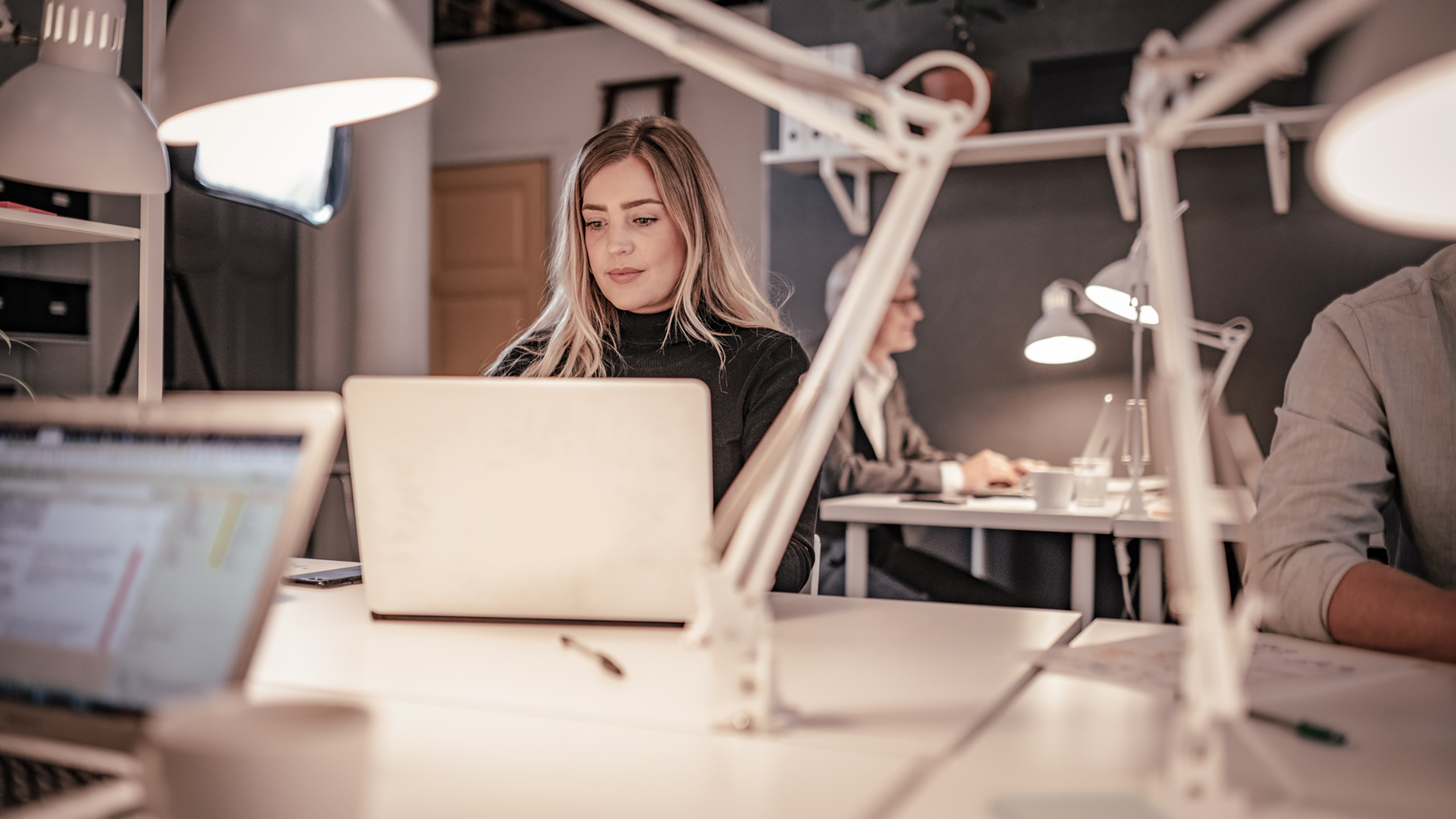 Kvinde arbejder på en computer i et kontormiljø
