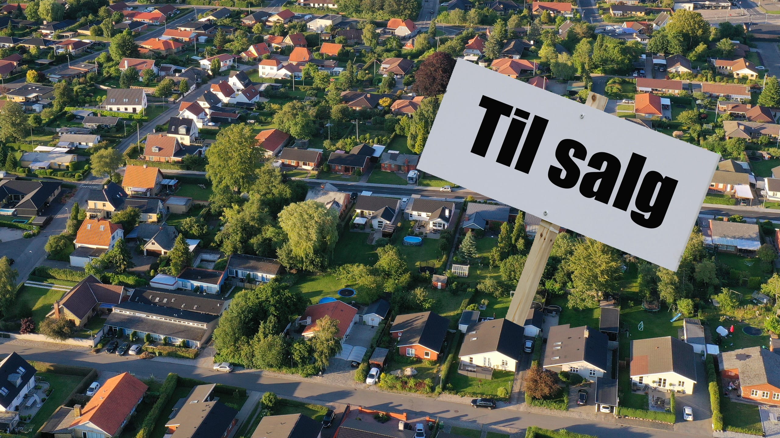 Huse set fra oven med 'Til salg'-skilt