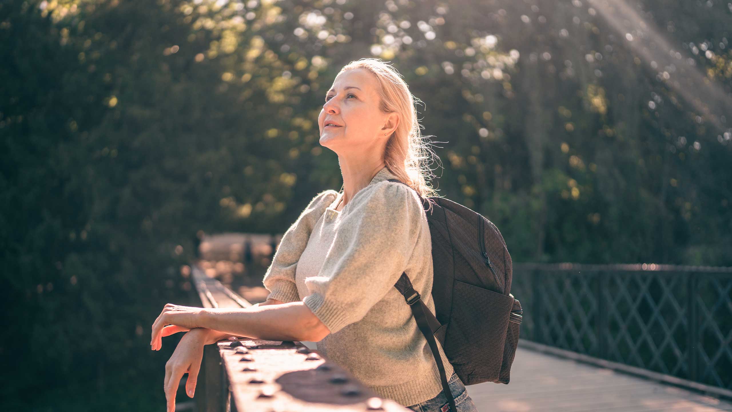 Kvinde med rygsæg på bro