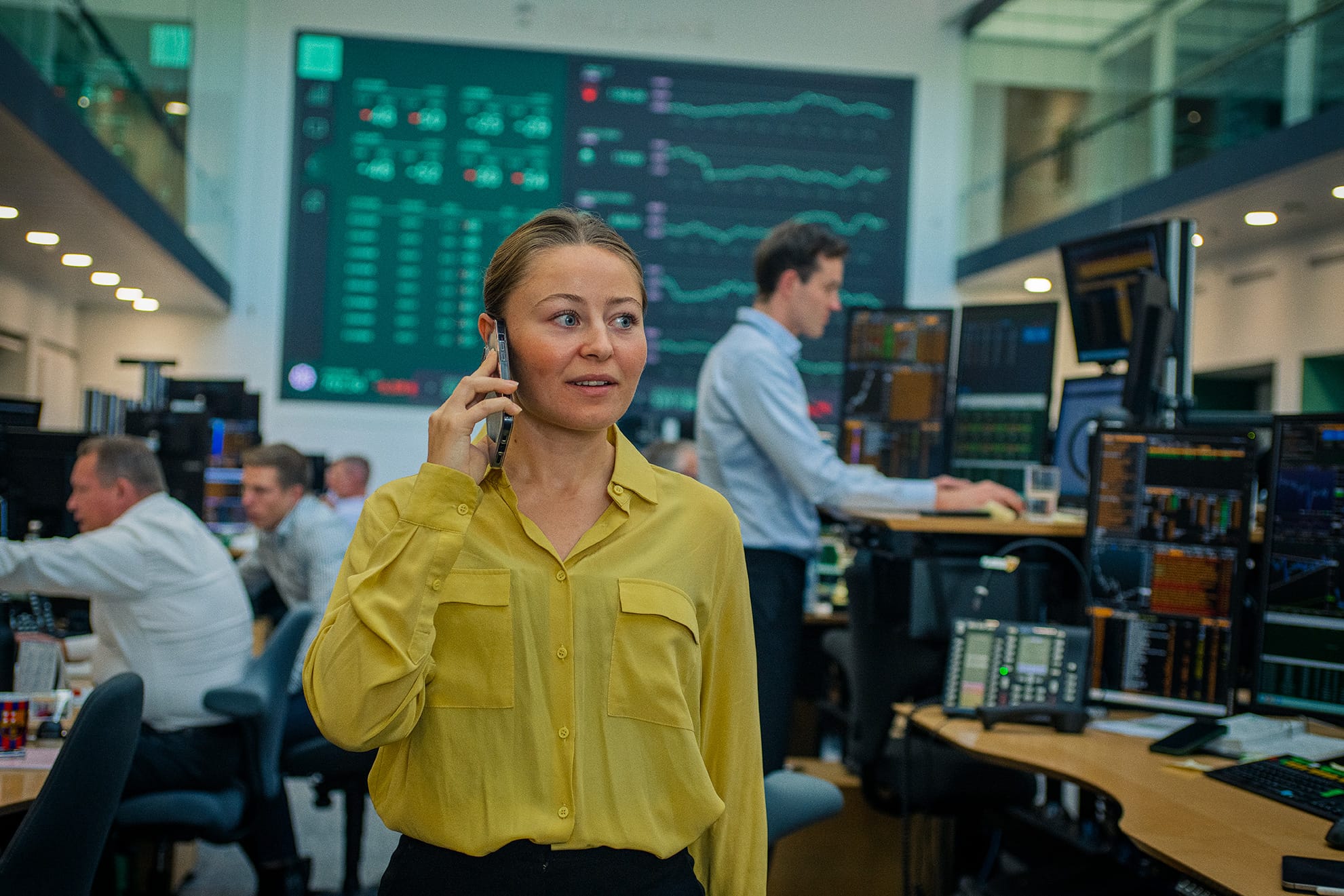 Kvinde taler i telefon i Jyske Banks Markets