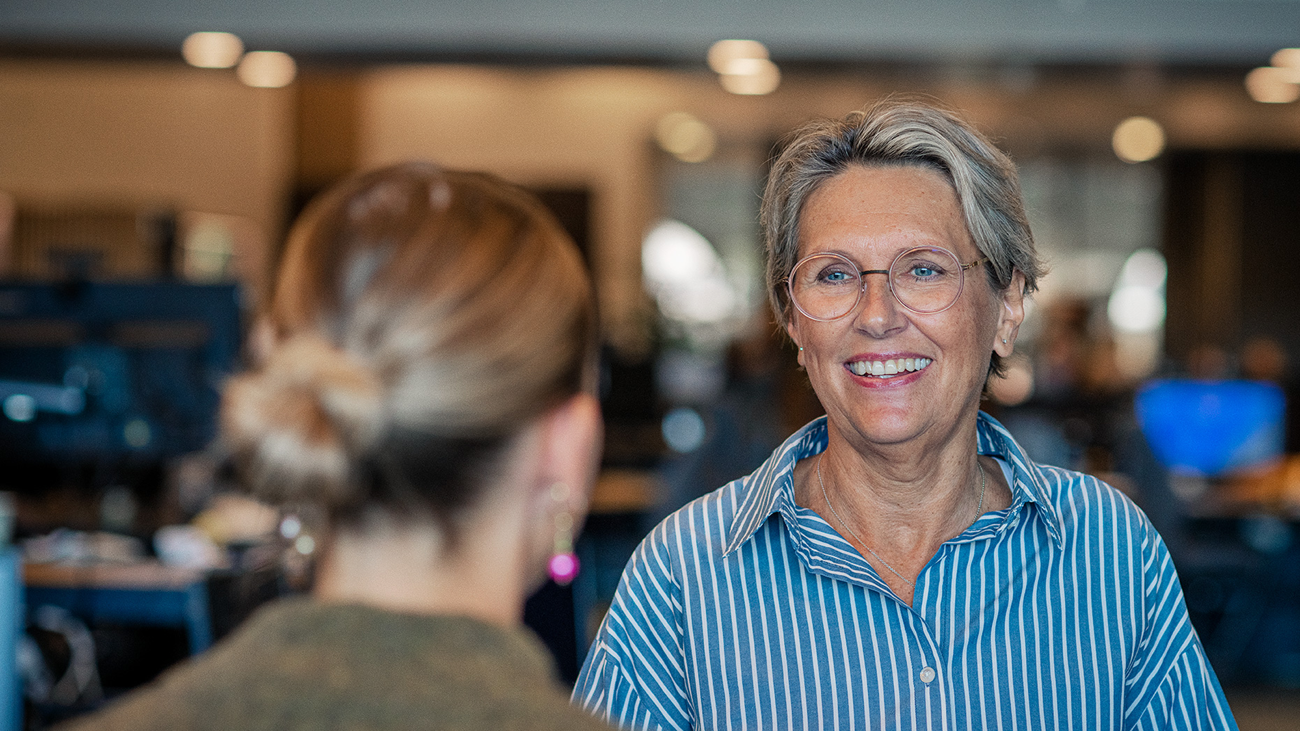 Smilende kvinde i stribet skjorte
