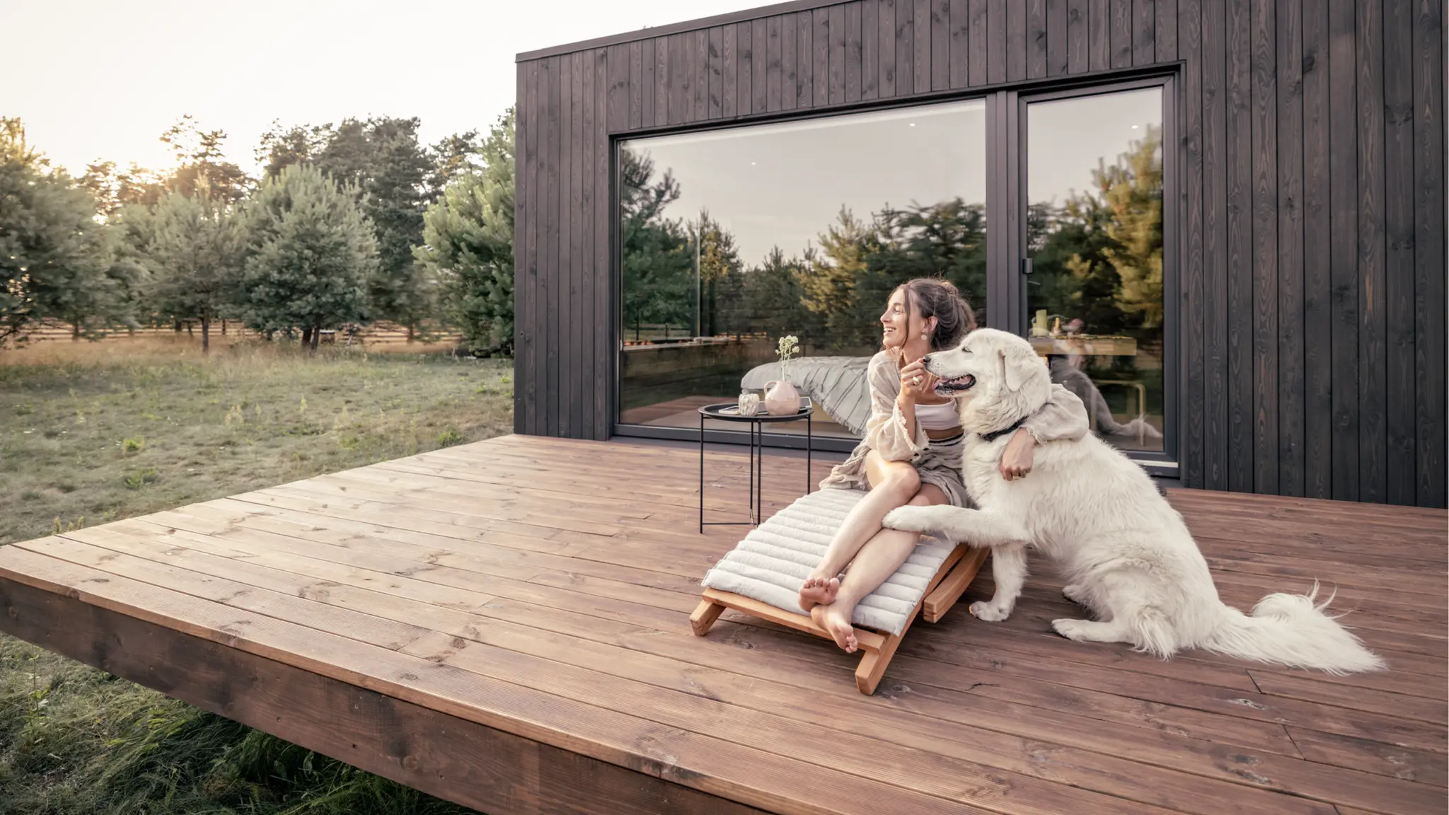 Kvinde på terrasse med hund ved sommerhus