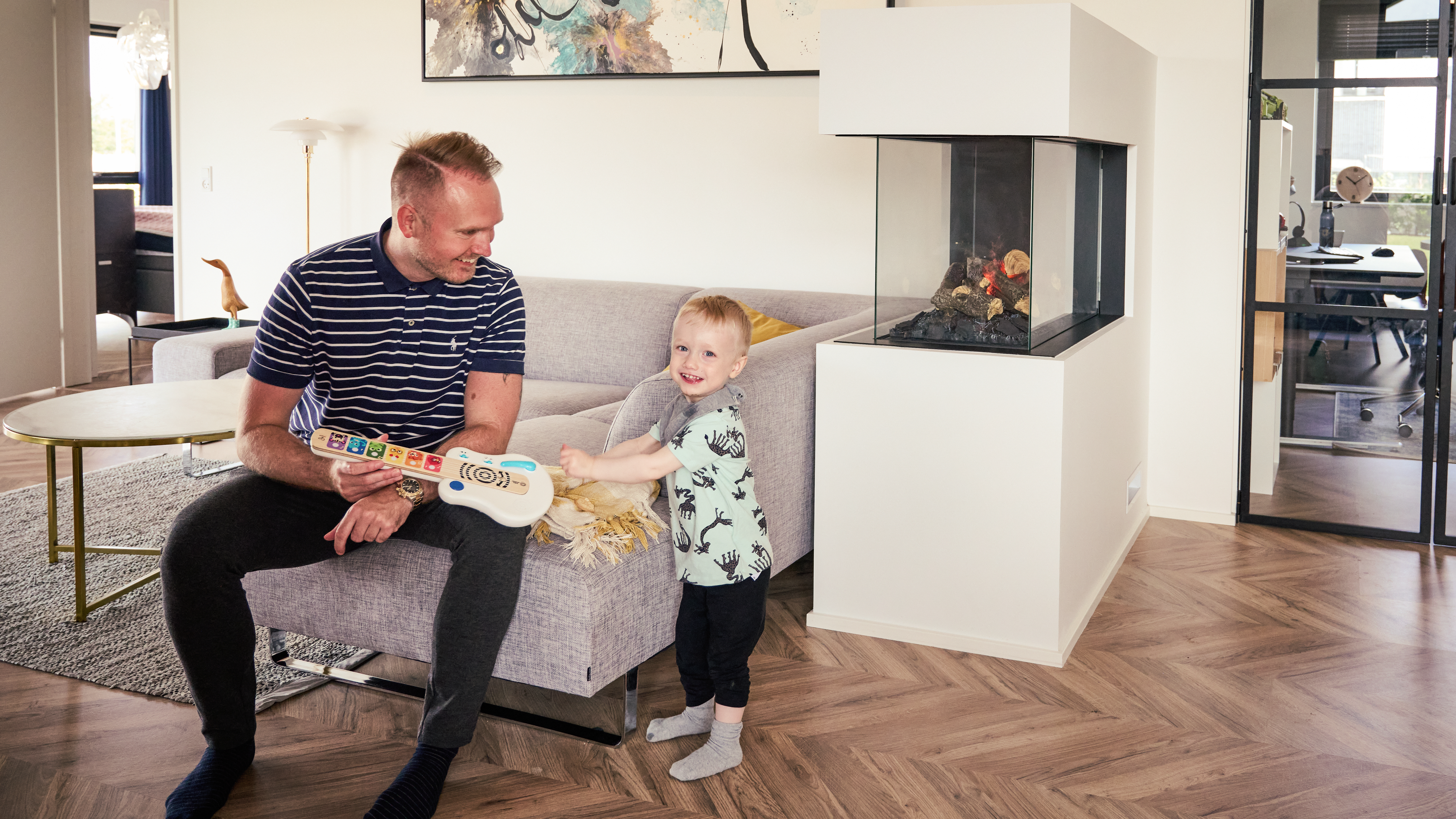 Far og søn i sofa med legetøj