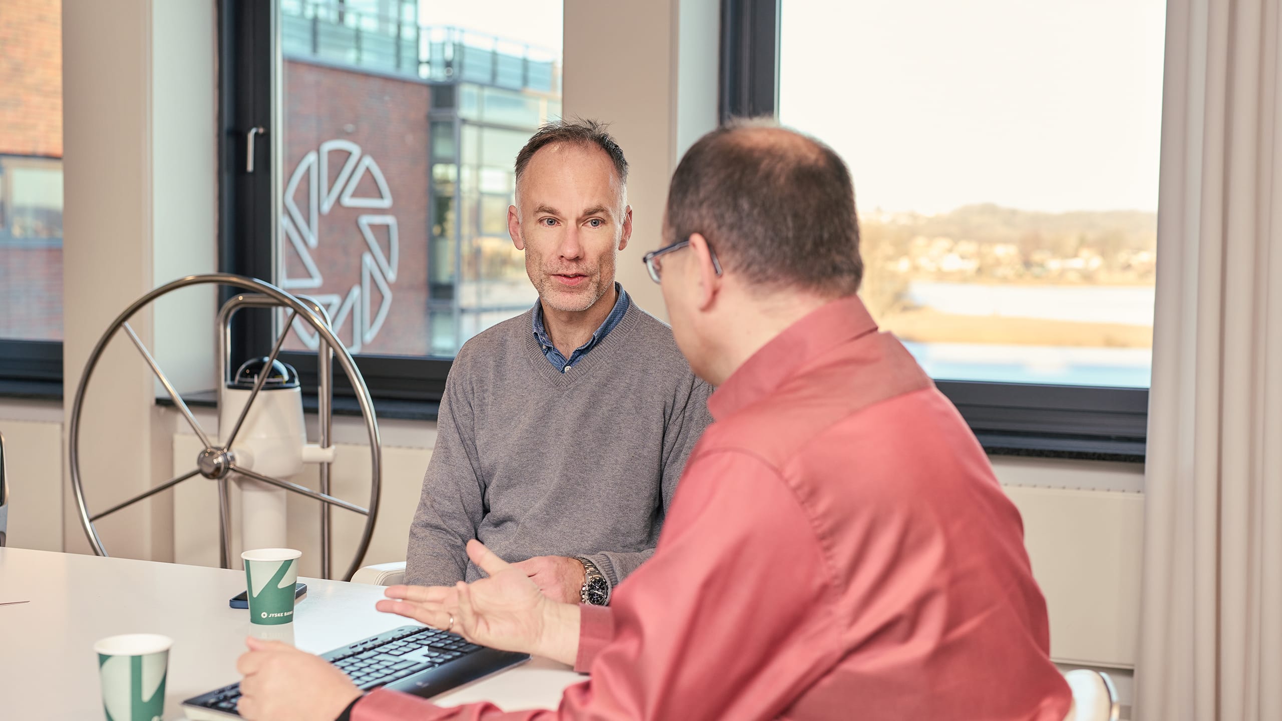 To mænd i møde - snakker om noget på papir