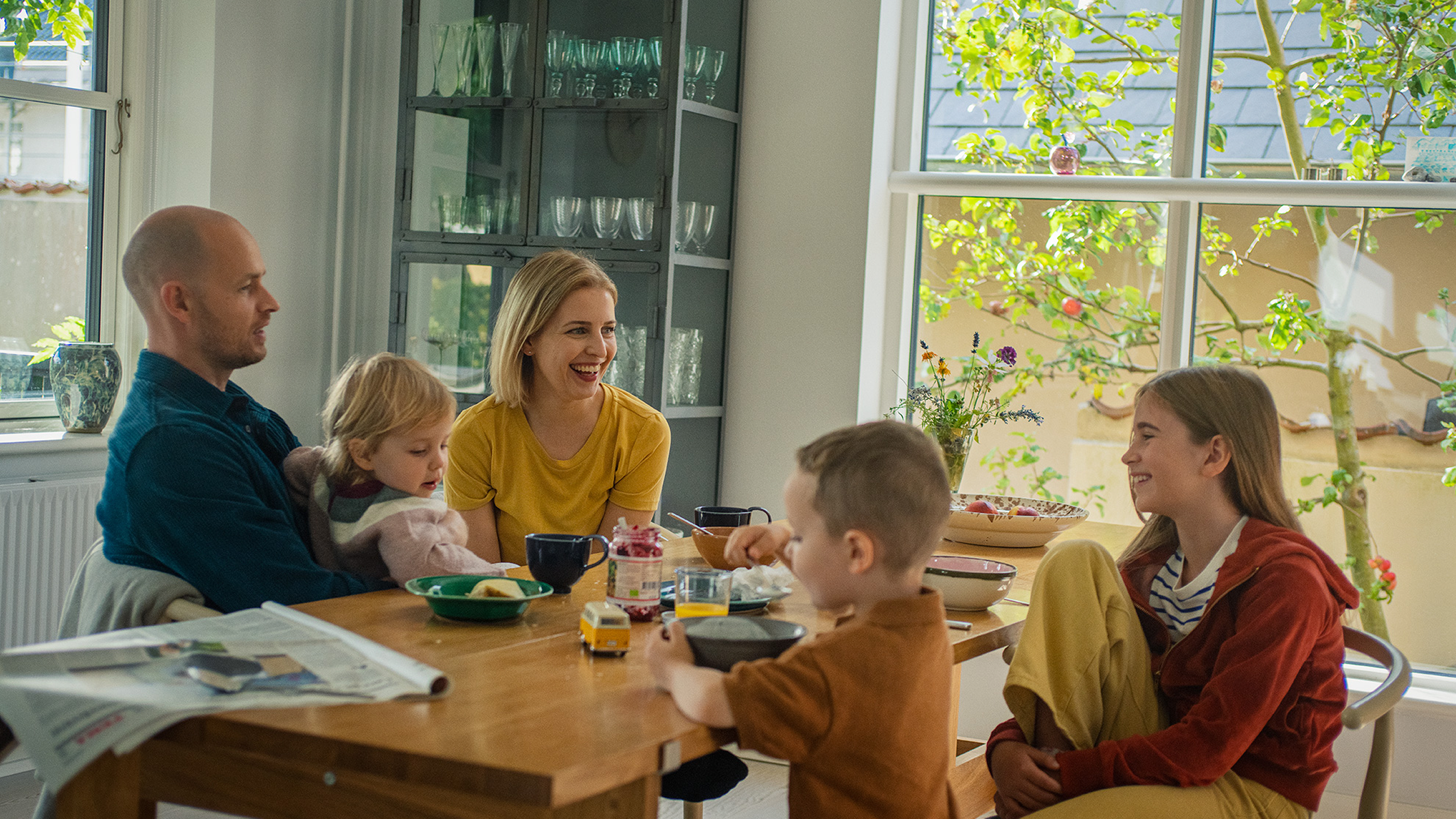 Familie sidder om spisebordet.