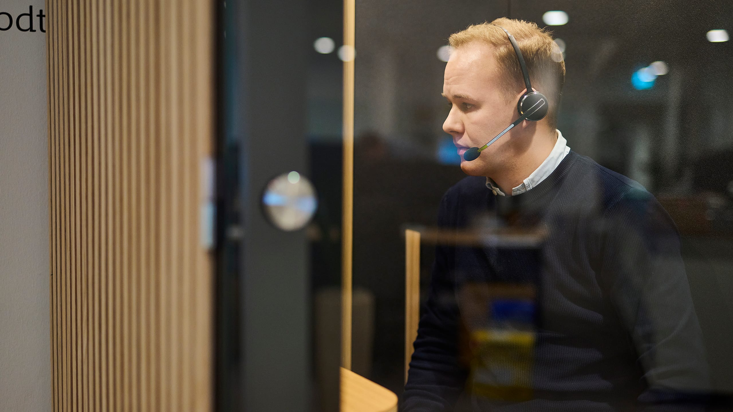Mand snakker i telefon via headset