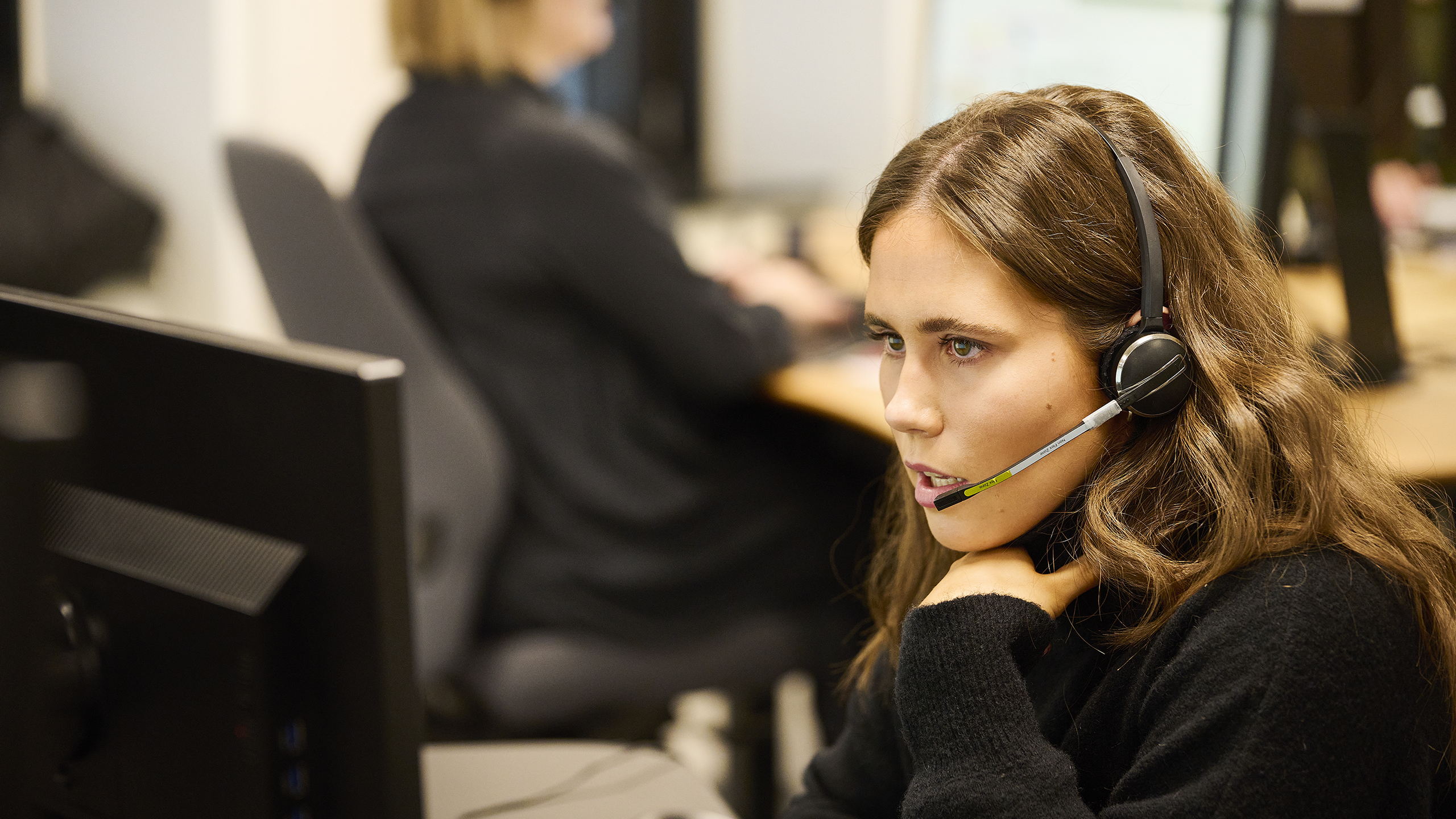 Kvinde med headset rådgiver via telefon