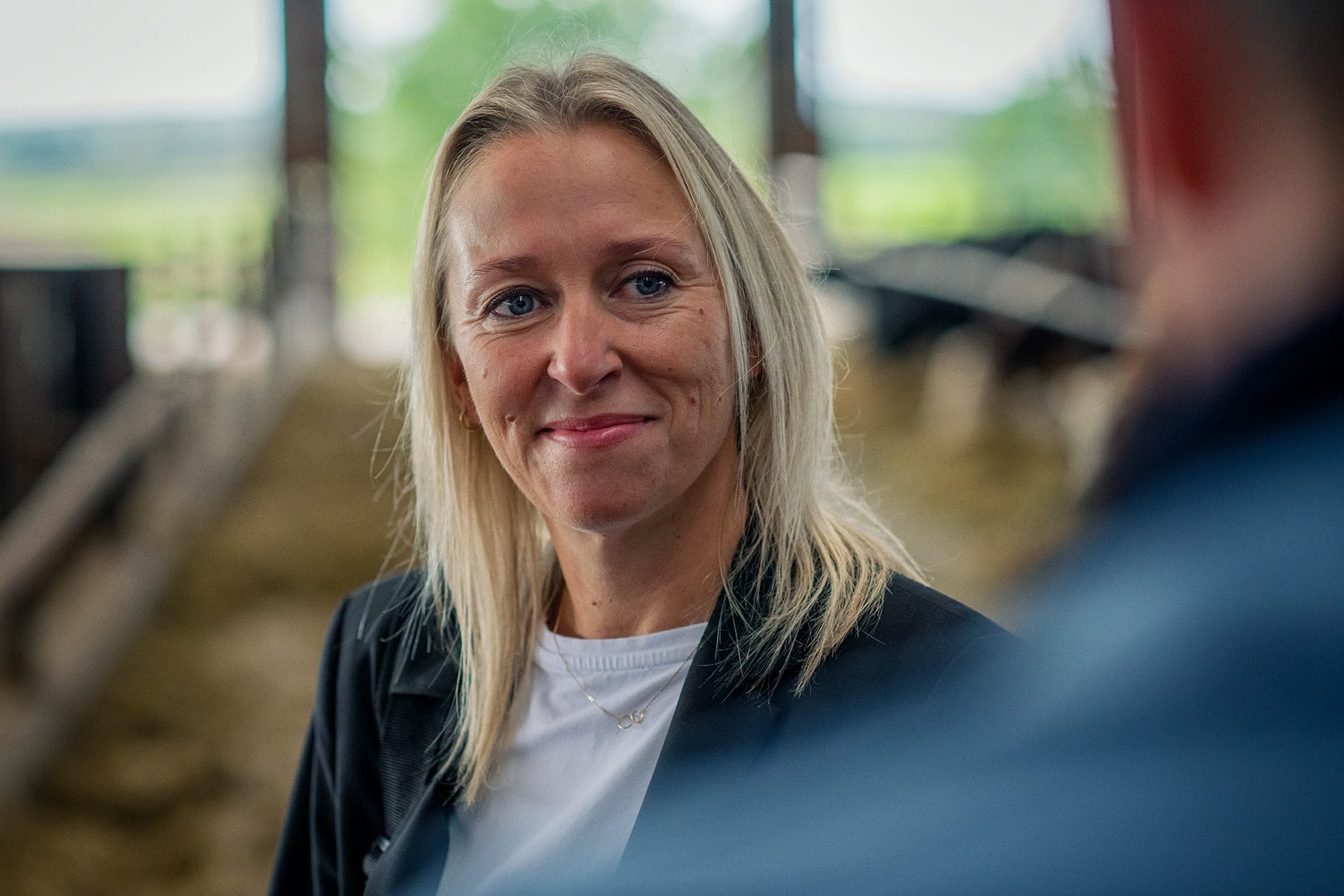 Kvinde fører samtale i stald