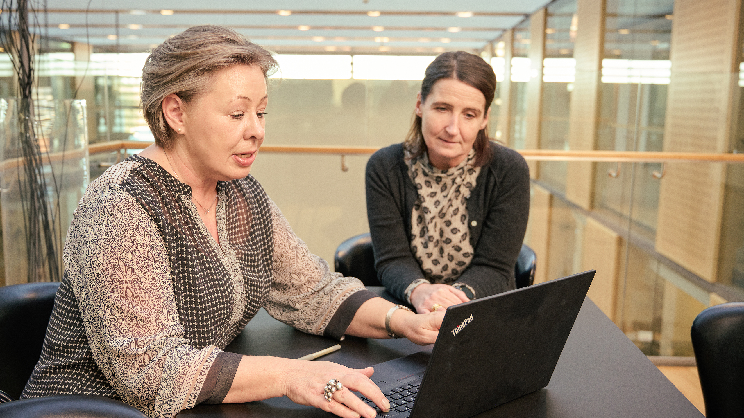 Bankrådgiver og kunde i møde ved computer