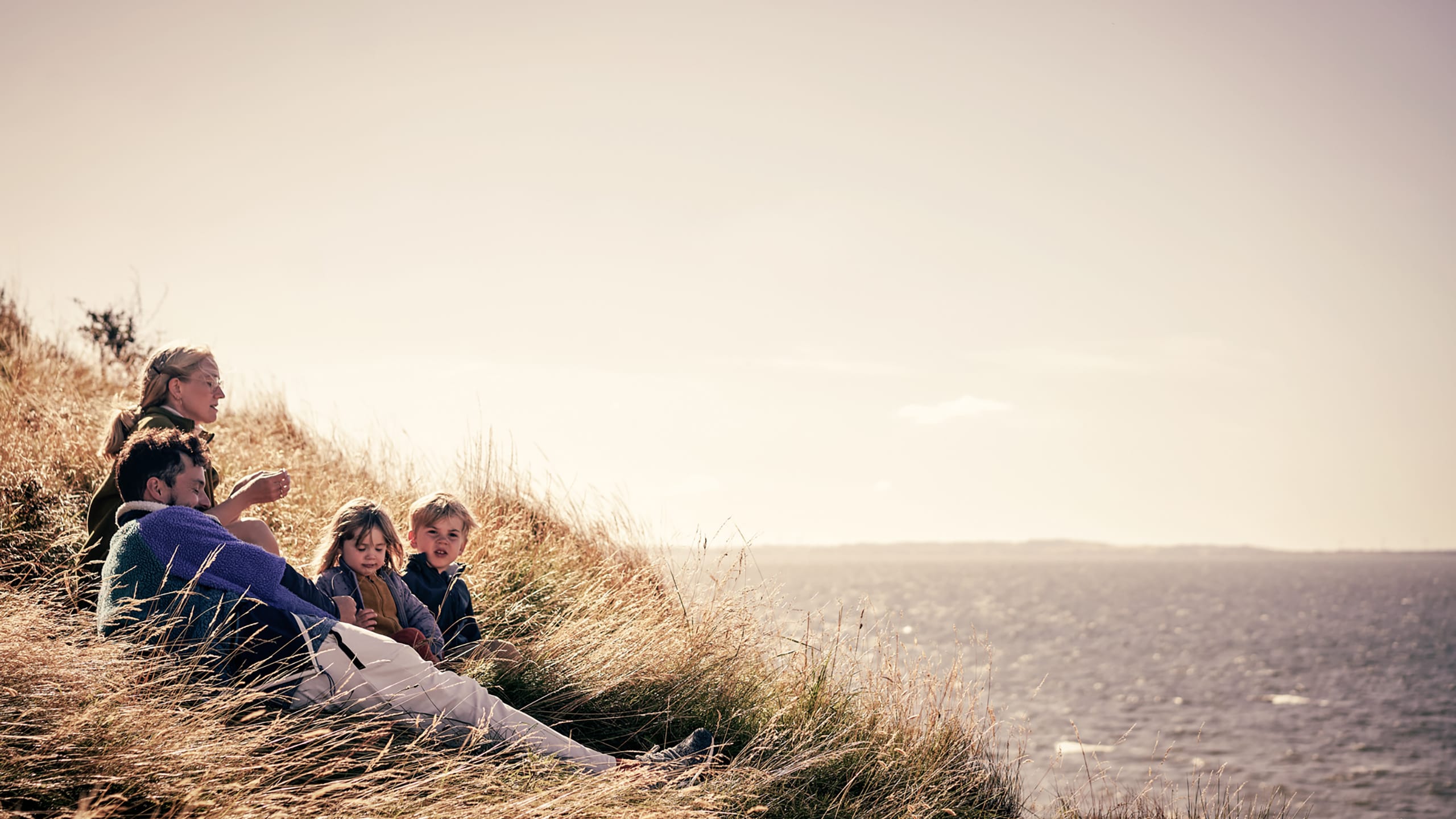 Familie slapper af i en klit ved havet